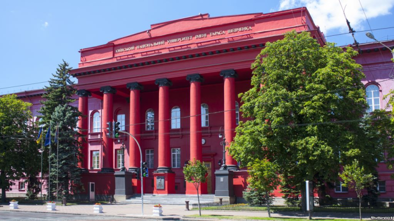 otynkowany na czerwono gmach główny Kijowskiego Narodowego Uniwersytetu (KNU) im. Tarasa Szewczenki; na pierwszym planie drzewa