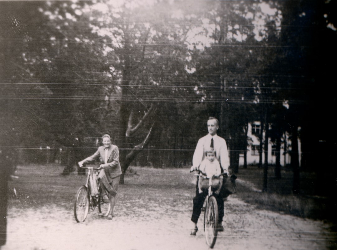 mężczyzna i kobieta jadą na rowerach; na rowerze z mężczyzna jedzie dziecko