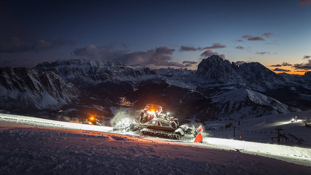 A snow groomer working in the vicinity of Seceda. The photo taken at night spent at the summit. Dolomites 2023