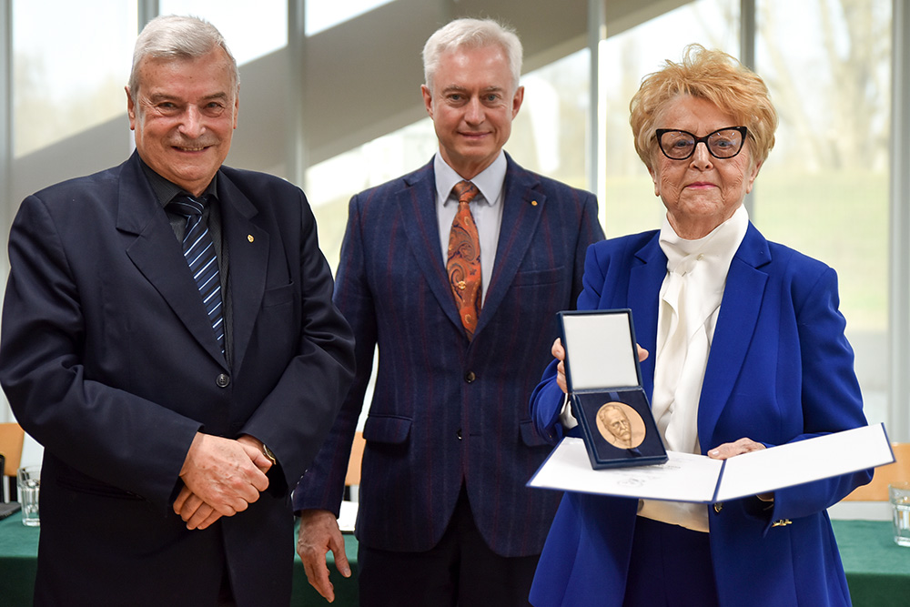 Dwóch mężczyzn i Kobieta trzymająca medal
