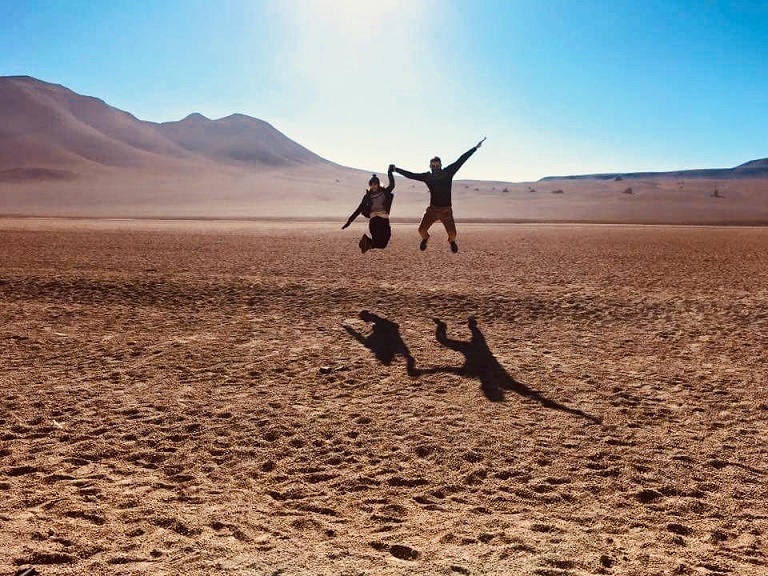 dwie osoby na pustyni skaczące do góry 