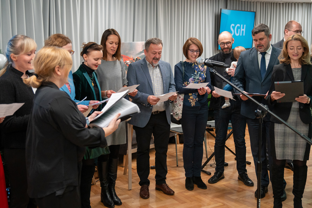 na zdjęciu grupa ludzi śpiewających do mikrofonu. Fot. Paweł Gołębiowski, SGH