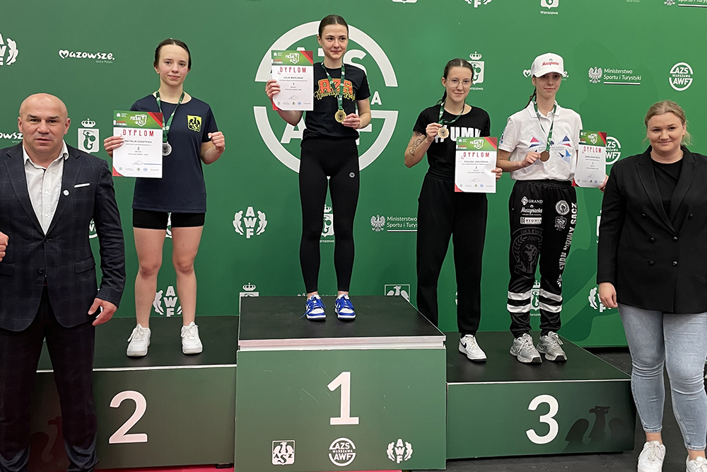Zdjęcie z podium, cztery kobiety oraz organizatorzy 