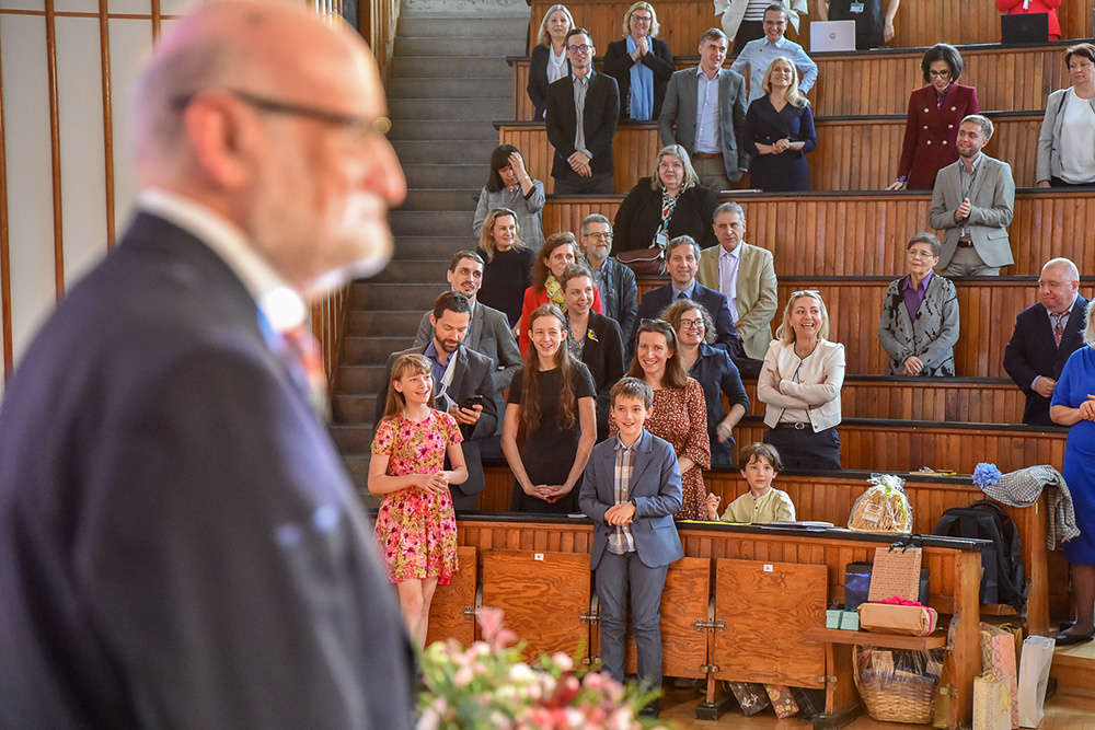 mężczyzna mówiący do gości zgromadzonych w auli
