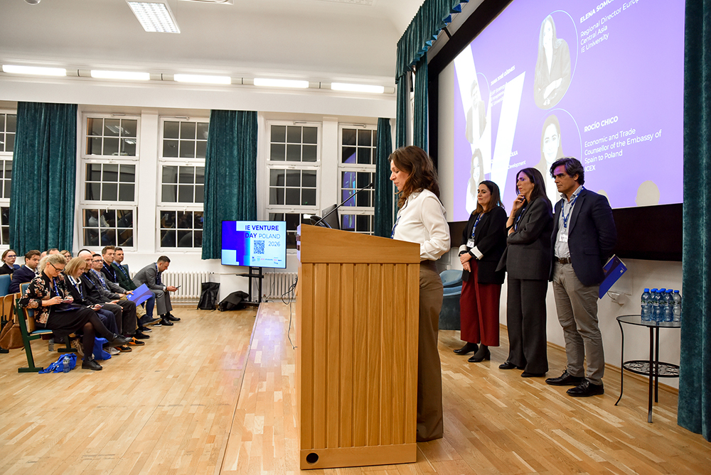 Na zdjęciu kobieta za mównicą za nią dwie kobiety i mężczyzna 