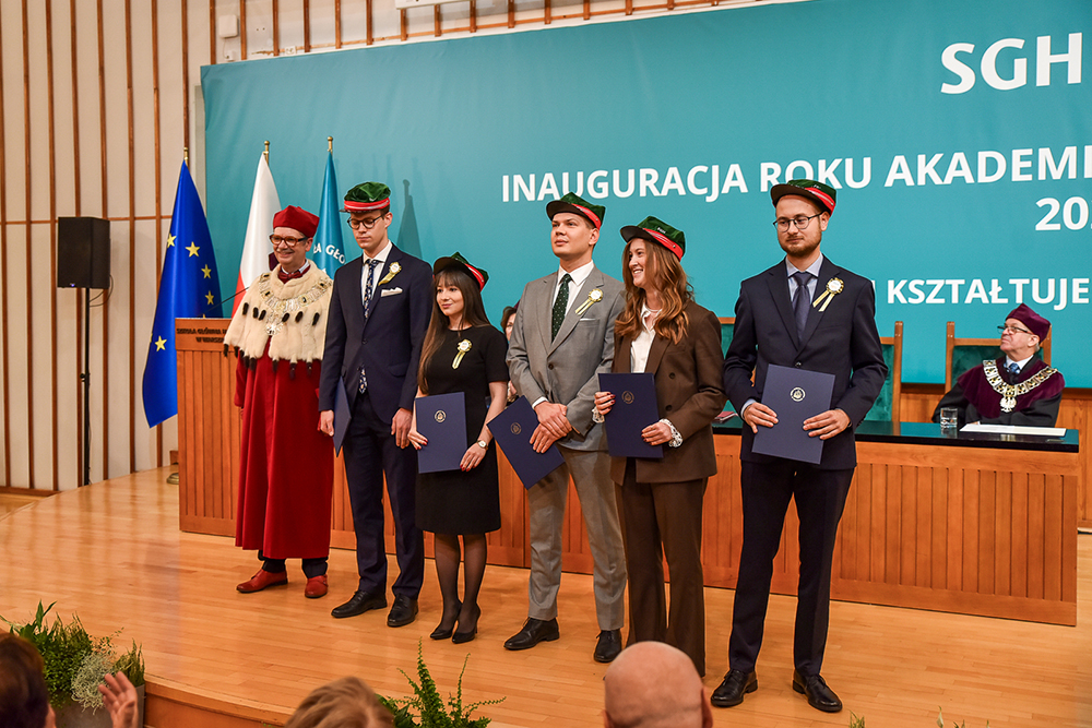 Grupa doktorantów stojąca z rektorem