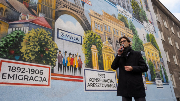 Tytus Brzozowski stoi przed muralem