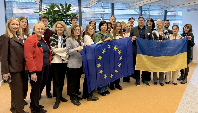 Grupa ludzi trzymająca flagi UE i Ukrainy