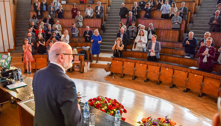 mężczyzna stojący przed uczestnikami konferencji w auli spadochronowej