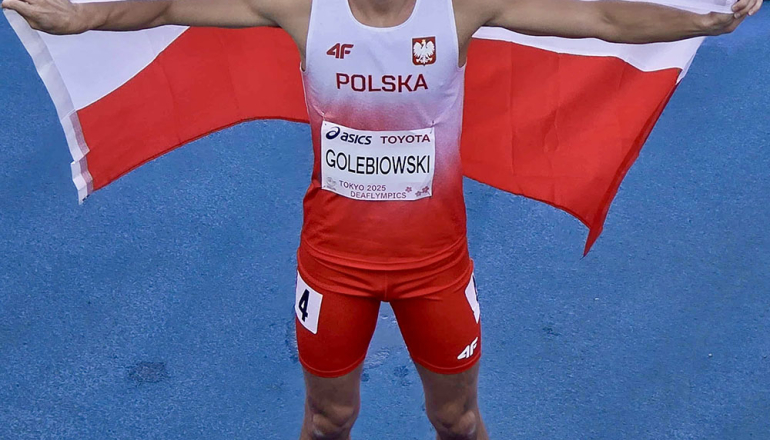 mężczyzna na bieżni z rozpostartą flagą Polski na plecach