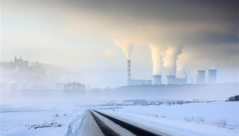 zaśnieżone pole, w oddali dymiące kominy