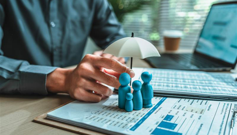 otwarte zeszyty, ludziki i dłoń człowieka trzymająca mały parasol