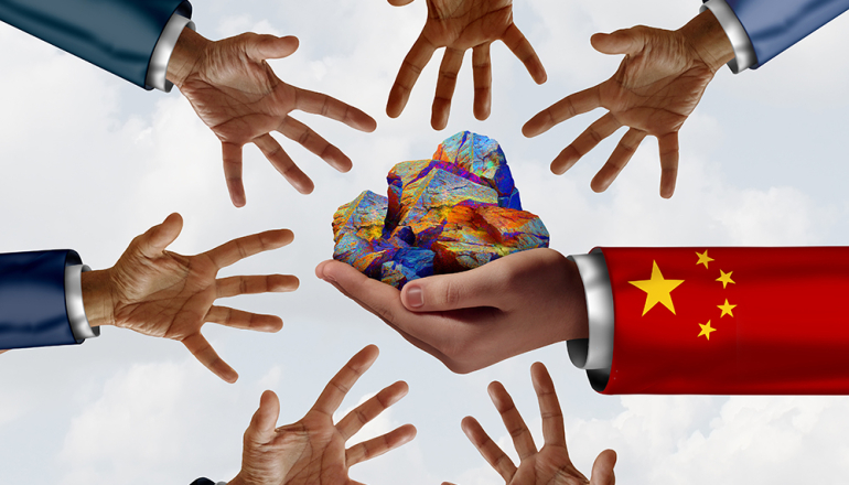 dłoń trzymająca kolorowe kamienie i wokół inne dłonie wyciągnięte w stronę tych kamieni