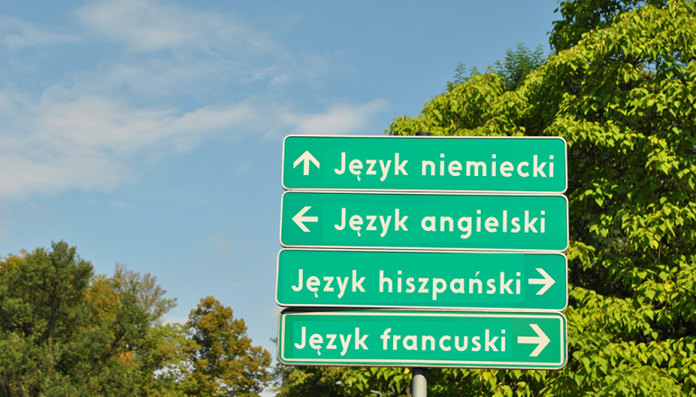 na zdjęciu drogowskazy drogowe z napisami języków obcych