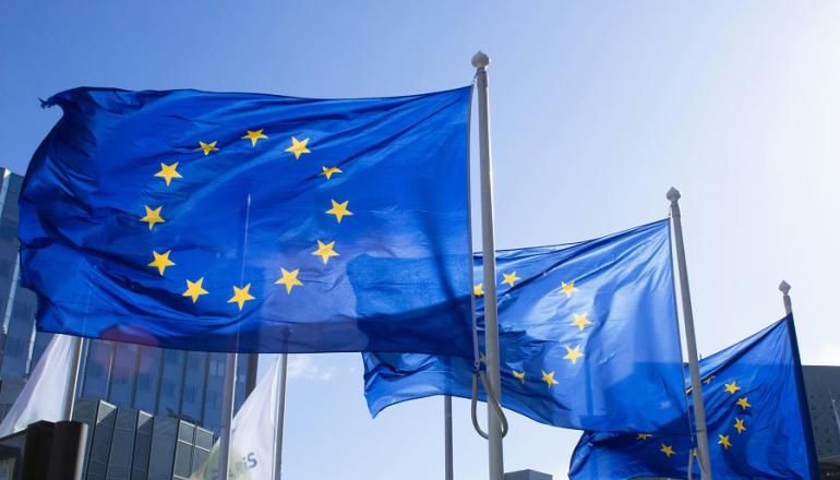 trzy powiewające flagi unijne