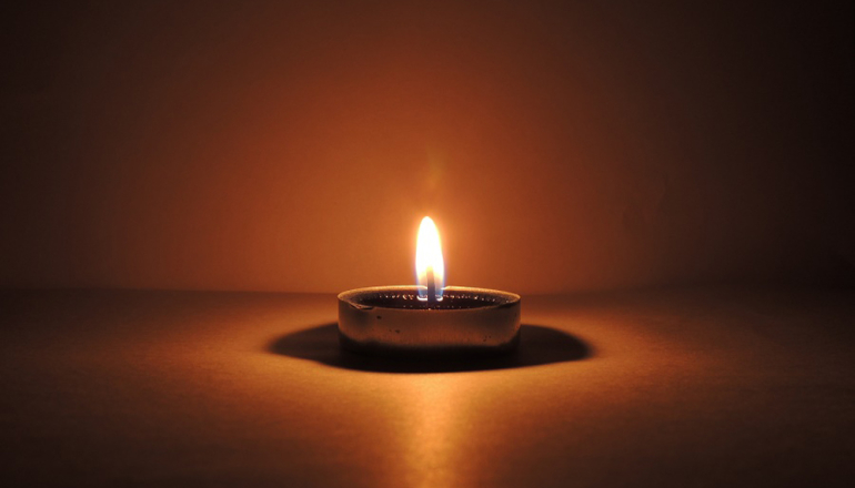 płonąca świeczka w ciemnym pomieszczeniu