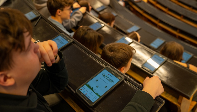 młodzi rozwiązują test wiedzy na jednej z uczelnianych auli