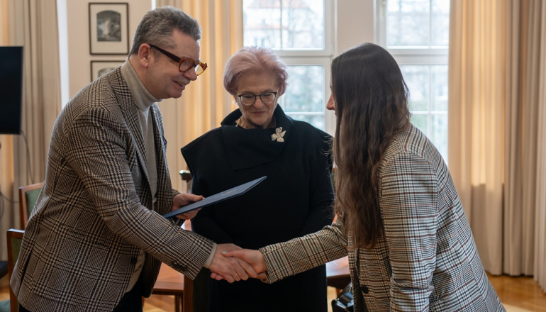 mężczyzna składa gratulacje młodej kobiecie, po środku druga kobieta