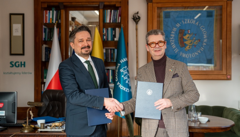 dwóch mężczyzn w gabinecie podaje sobie dłonie po podpisaniu porozumienia