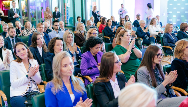 kilkadziesiąt osób siedzi na sali 