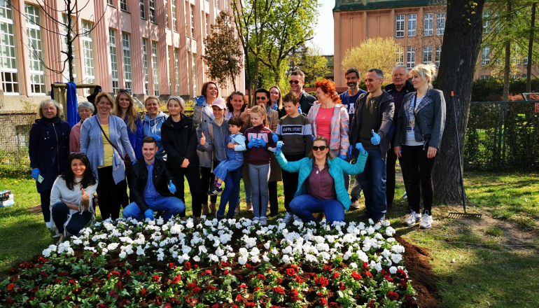 Na zdjęciu: społeczność akademicka SGH przy łące kwiatowej w barwach narodowych 