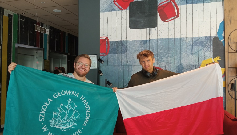 dwóch mężczyzn trzyma flagi Polski i SGH