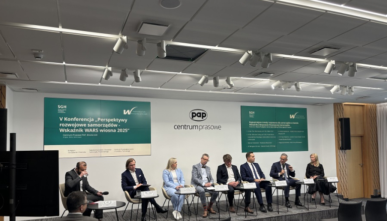 kilka osób siedzi w centrum prasowym i dyskutuje