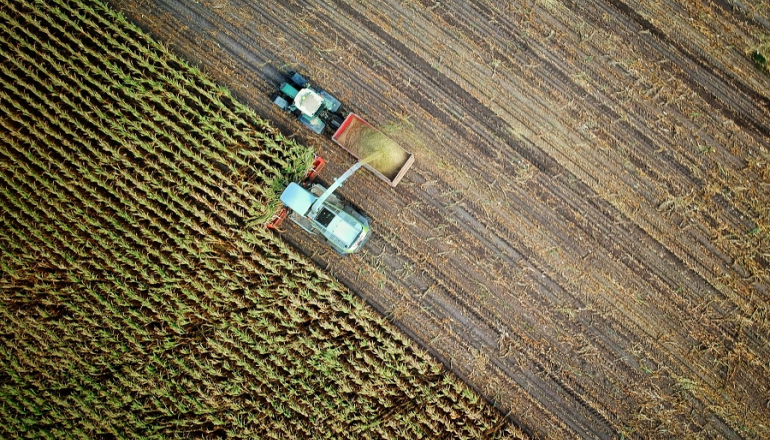 traktor i kombajn pracują na polu; zdjęcie z lotu ptaka