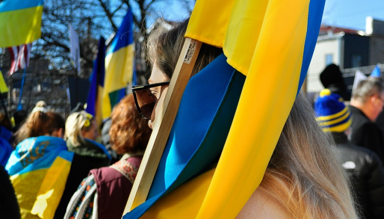 ludzie niosą ukraińskie flagi podczas demonstracji