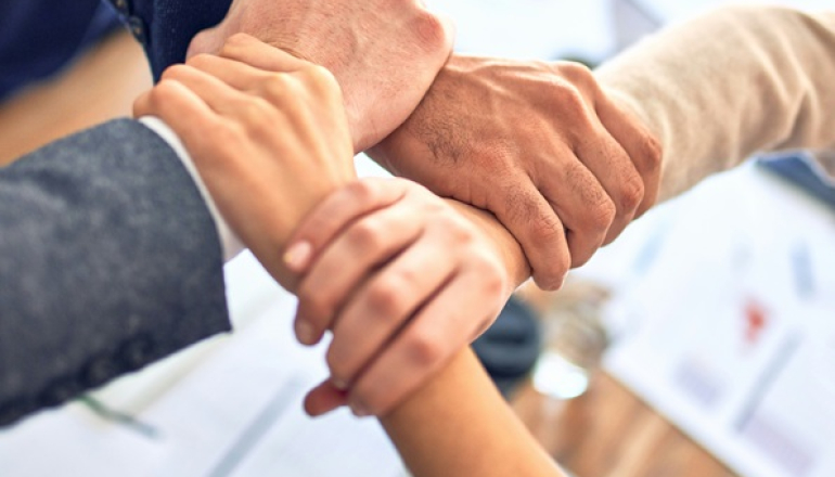 cztery osoby trzymają się za nadgarstki