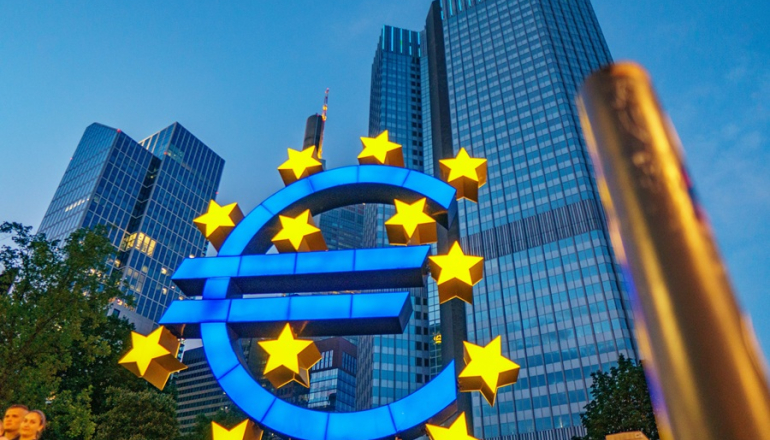 symbol euro z gwiazdami UE na tle wieżowców