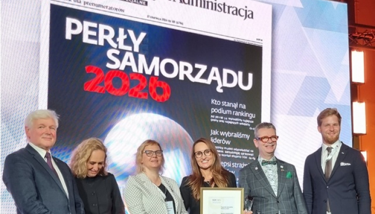 kilka osób na scenie, w tle wyświetlany napis
