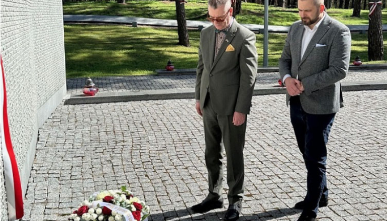 dwóch mężczyzn składa wiązankę