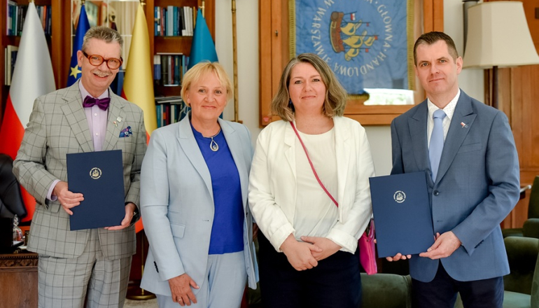 dwie kobiety i dwóch mężczyzn w gabinecie po podpisaniu porozumienia