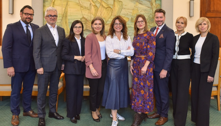 grupa osób pozuje do zdjęcia w sali uczelni