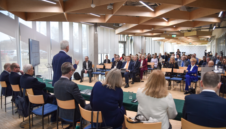 zdjecie zrobione z perspektywy stołu prezydialnego - cała sala pełna ludzi na spotkaniu