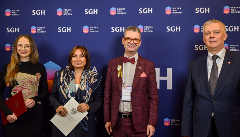 dwóch mężczyzn i dwie kobiety pozują do zdjęcia na tle ścianki