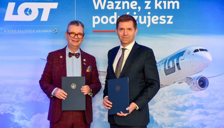 dwóch mężczyzn na tle ścianki z samolotem