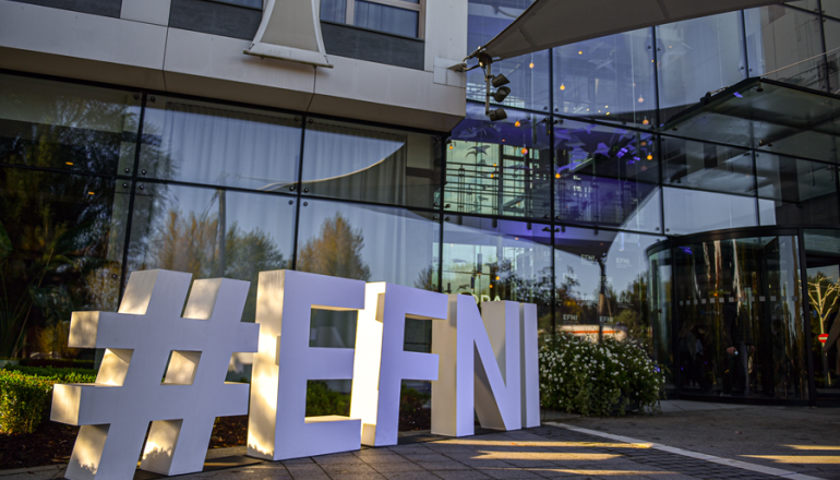 duże białe litery ułożone na ziemi układające się w napis: #EFNI