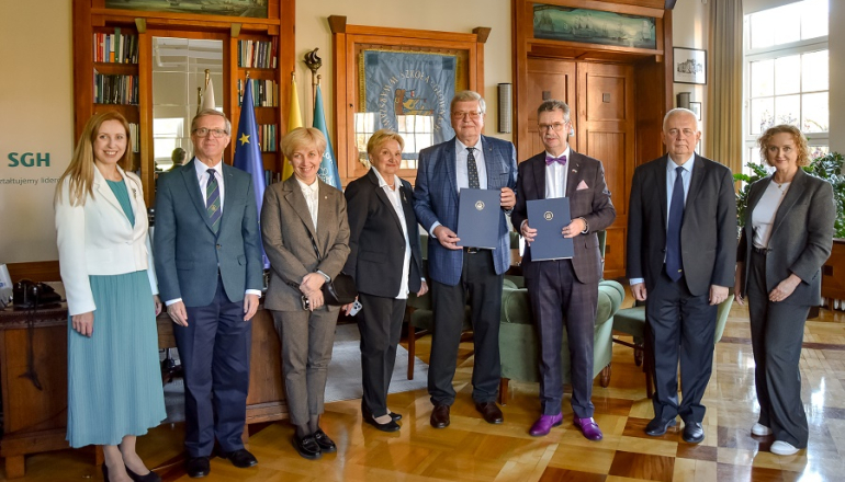 grupa osób pozuje do zdjęcia w gabinecie rektora
