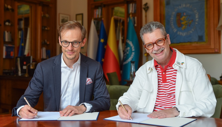 dwóch mężczyzn podpisuje umowę