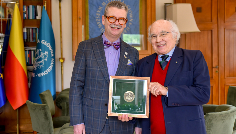 dwóch mężczyzn w gabinecie pokazuje medal za zasługi 