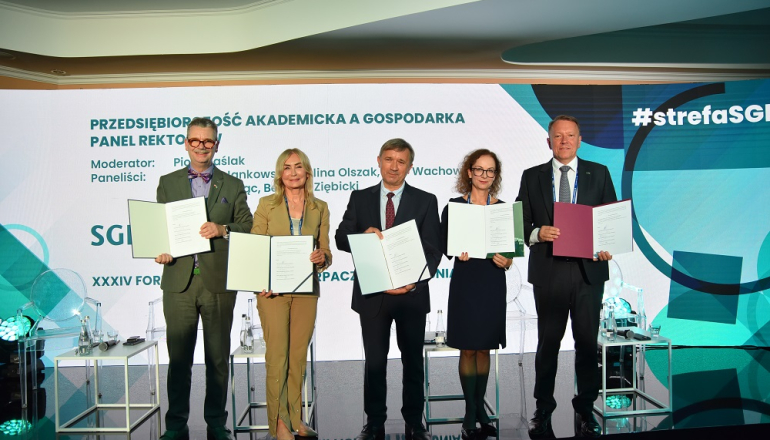 Na zdjęciu dwie kobiety i trzech mężczyzn trzymający w dłoniach teczki