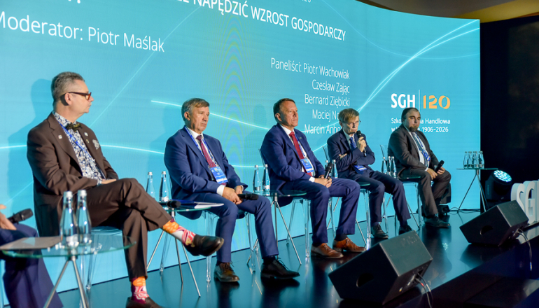 kilka osób rozmawia na scenie na panelu