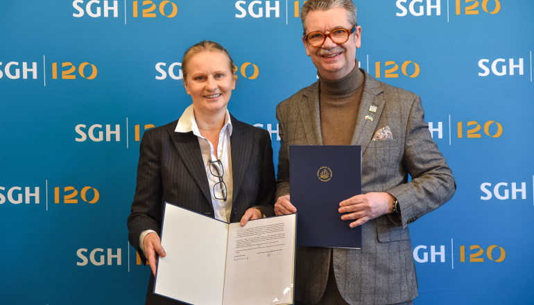 mężczyzna i kobieta pozują do zdjęcia z podpisanym porozumieniem