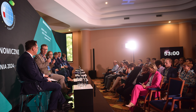 sala wypełniona publicznością i prowadzący - panel 