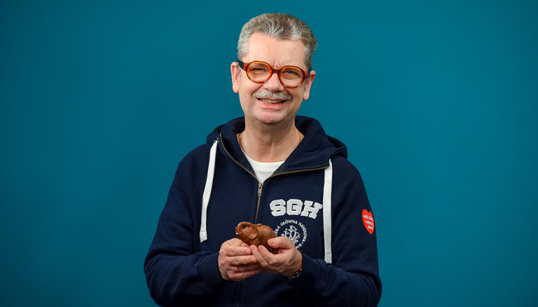 mężczyzna w bluzie SGH z logo WOŚP trzymający słonia