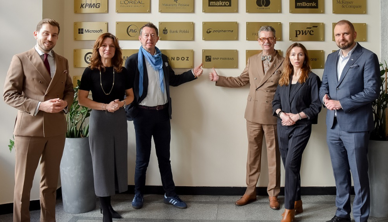 na zdjęciu kilkoro osób pod tablica Klubu artnerów