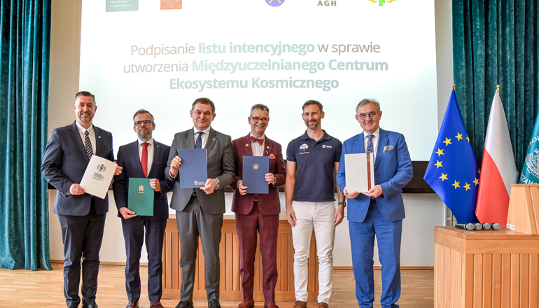 pięciu mężczyzn po podpisaniu dokumentu, w tle slajd z napisem