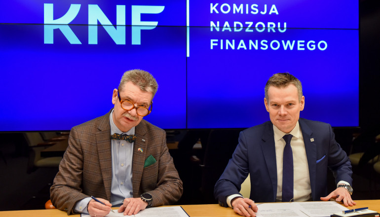 dwóch mężczyzn podpisuje dokument